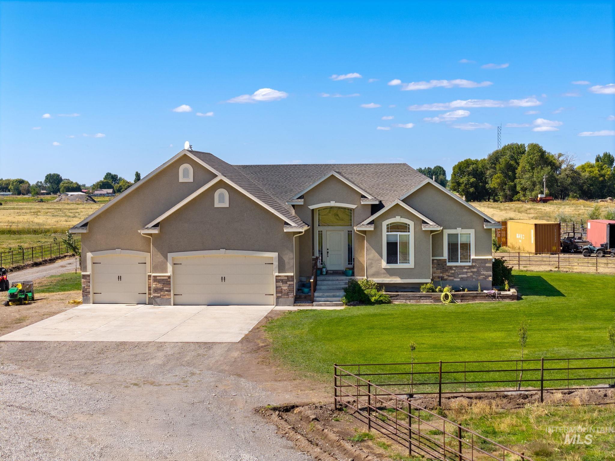3625 North 2000 West Rexburg, ID 83440 - Photo 1 of 50 Craftsman house featuring driveway, stucco siding, a view of countryside, and a garage