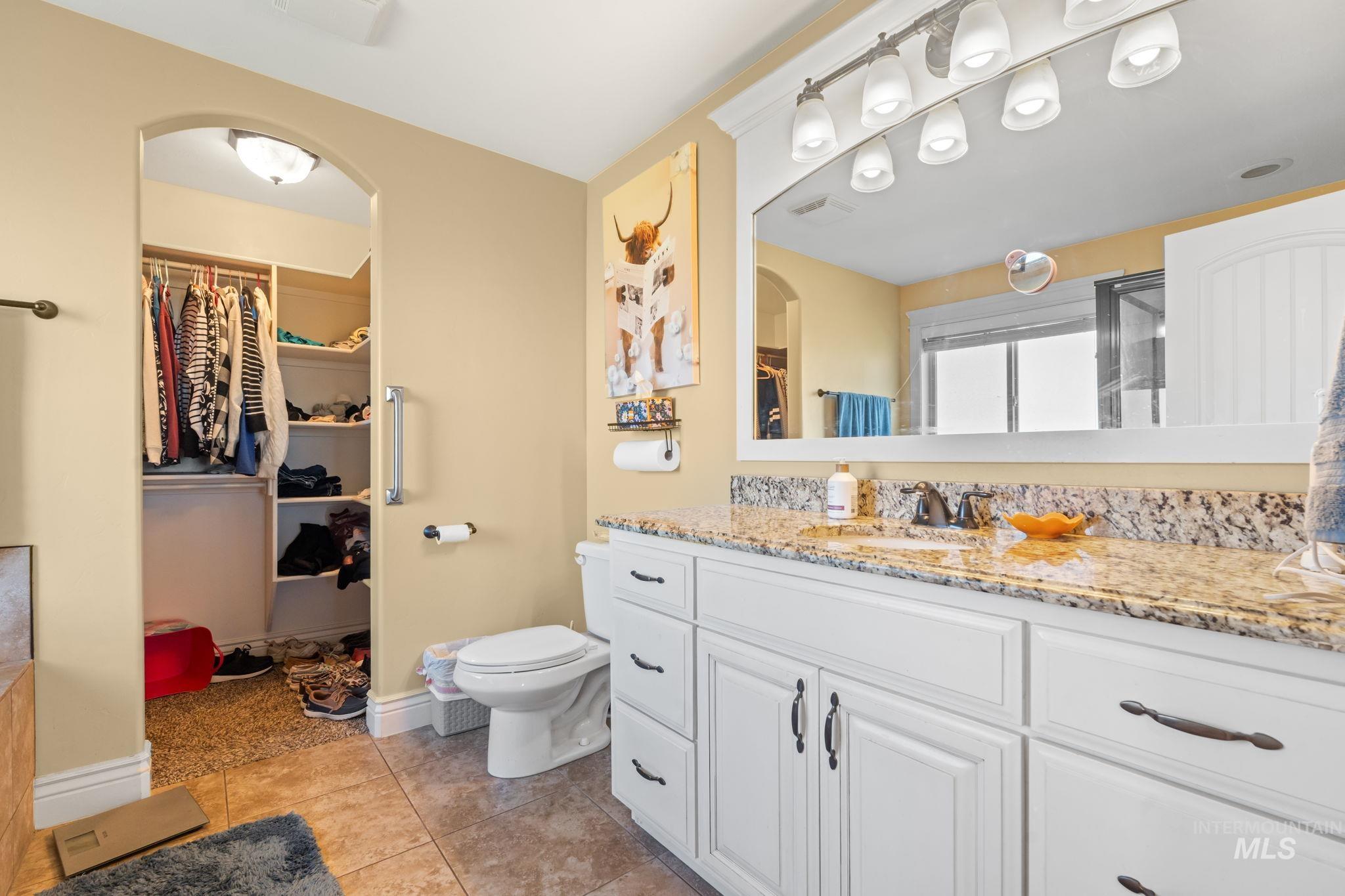 3625 North 2000 West Rexburg, ID 83440 - Photo 14 of 50 Full bathroom featuring a walk in closet, vanity, light tile patterned floors, and a shower