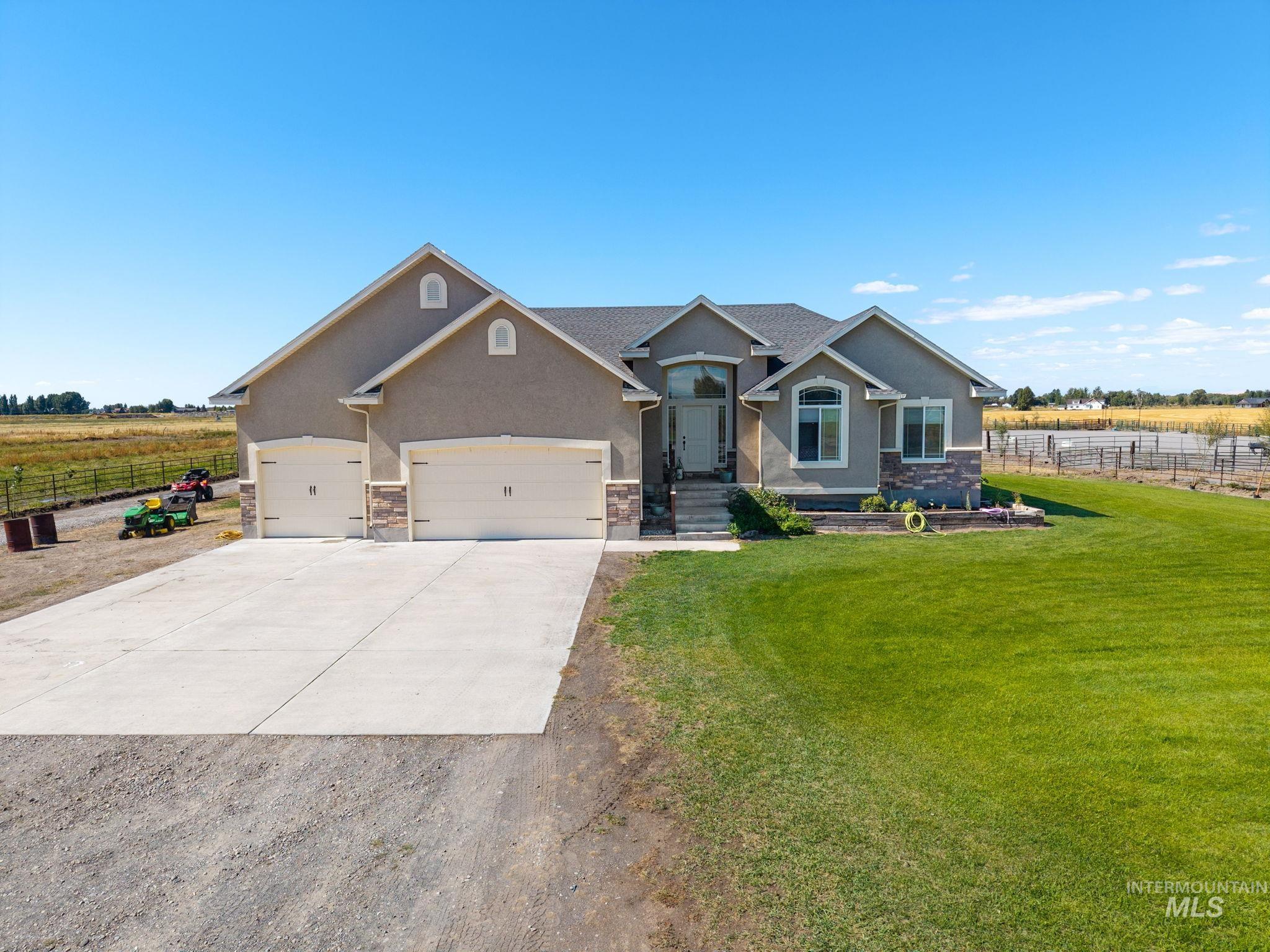 3625 North 2000 West Rexburg, ID 83440 - Photo 30 of 50 Craftsman house featuring stucco siding, concrete driveway, a view of countryside, and stone siding