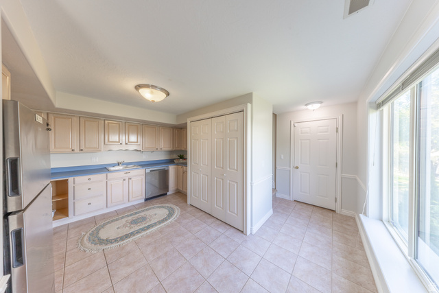 144 Bountiful Boulevard Bountiful, UT 84010 - Photo 27 of 28 Kitchen with stainless steel appliances, light wood finish cabinets, light tile patterned flooring, and light countertops