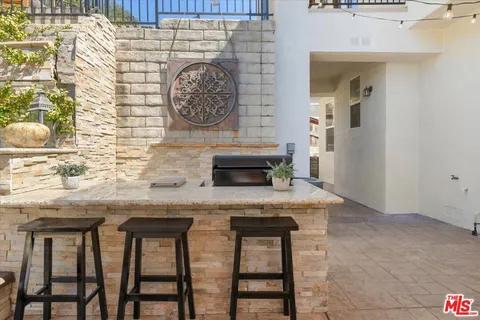 a living room with stainless steel appliances granite countertop furniture a couch and a window
