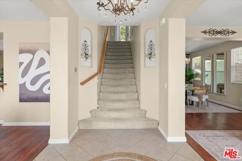 a view of a patio with couches table and chairs under an umbrella with a fire pit