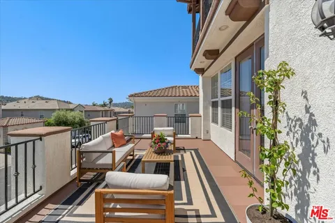 a view of a patio with couches table and chairs and potted plants