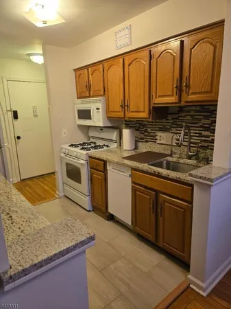 a kitchen with stainless steel appliances granite countertop a stove sink and cabinets