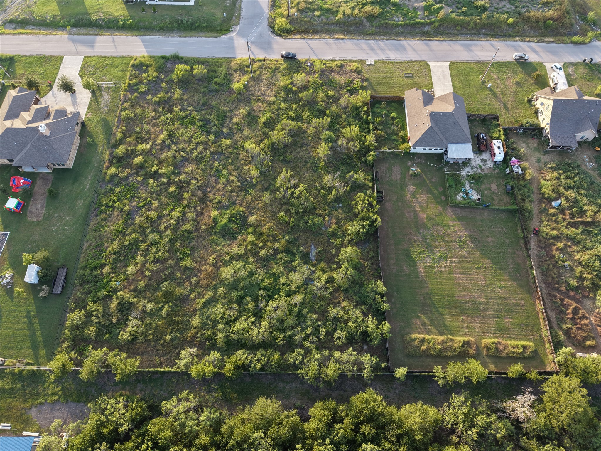 232 East Ridge Lane Kyle, TX 78640 - Photo 20 of 36 A spacious, buildable lot awaits your vision, bordered by residential properties and a paved street.