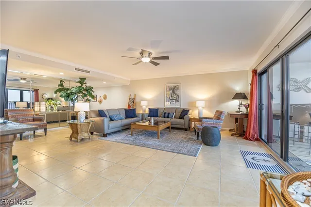 a living room with furniture potted plant and a large window