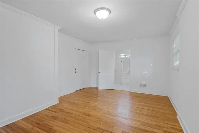 a view of an empty room with wooden floor