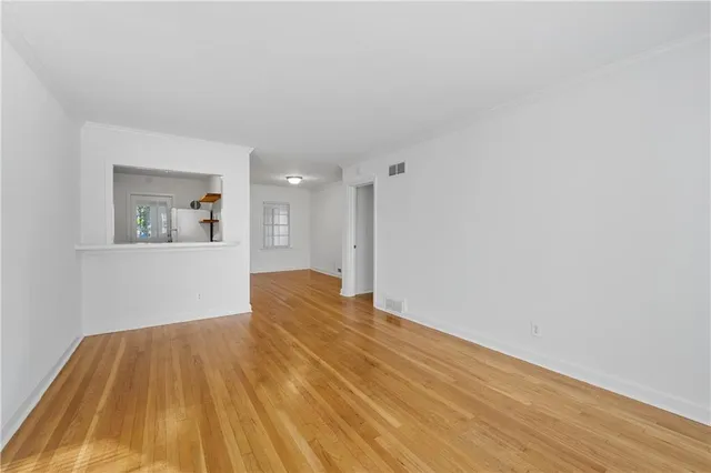 a view of a big room with wooden floor and windows