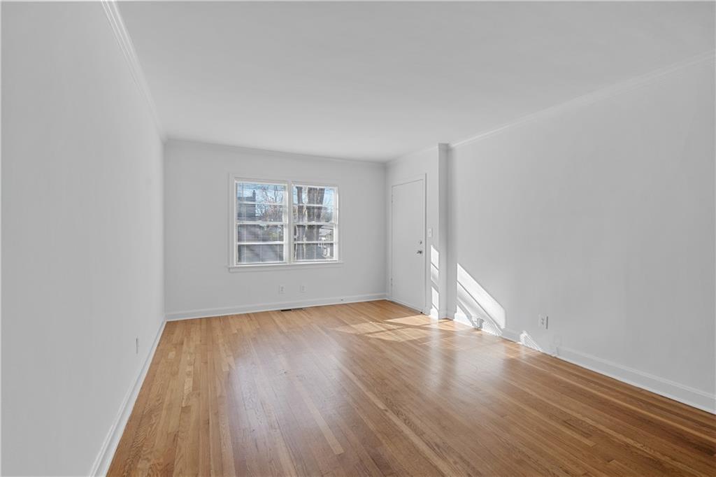 56 Mobile Avenue Northeast, Unit B Atlanta, GA 30305 - Photo 5 of 21 an empty room with wooden floor and windows