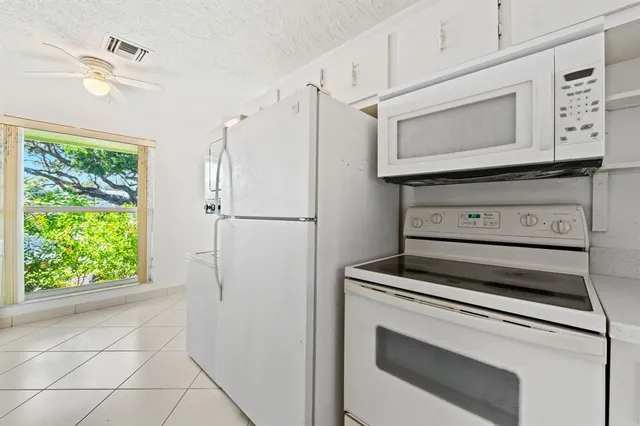 a kitchen with white cabinets and white appliances