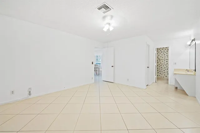an empty room with chandelier fan