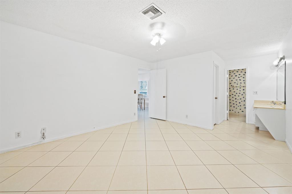 1271 Northwest 18th Avenue, Unit 5C Delray Beach, FL 33445 - Photo 17 of 36 an empty room with chandelier fan