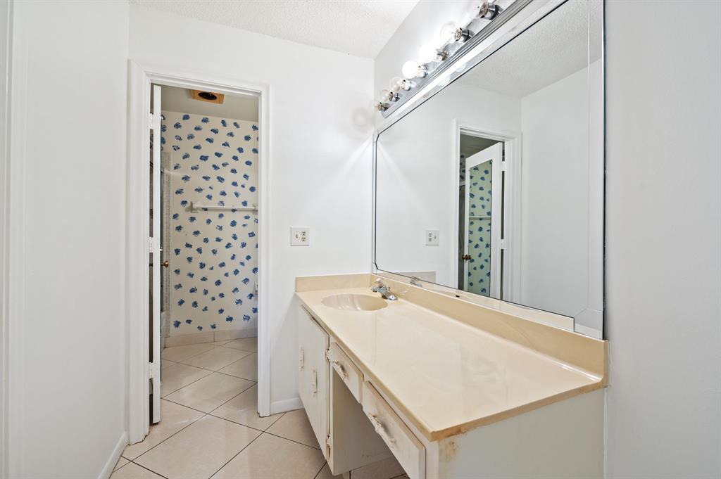 1271 Northwest 18th Avenue, Unit 5C Delray Beach, FL 33445 - Photo 18 of 36 a bathroom with a sink a vanity and a shower