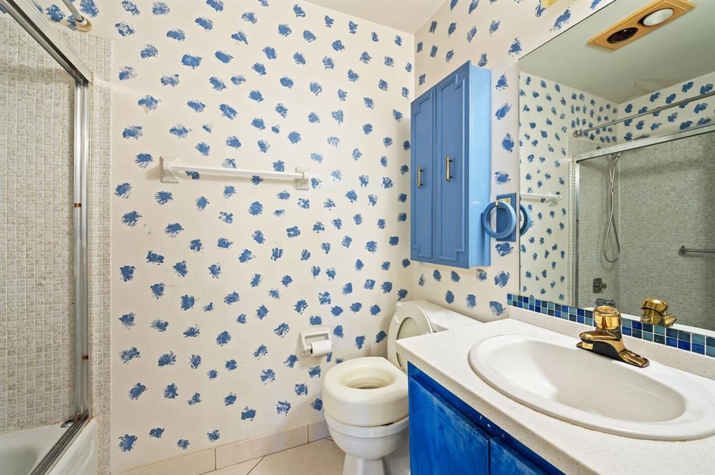 1271 Northwest 18th Avenue, Unit 5C Delray Beach, FL 33445 - Photo 20 of 36 a bathroom with a sink toilet and a mirror