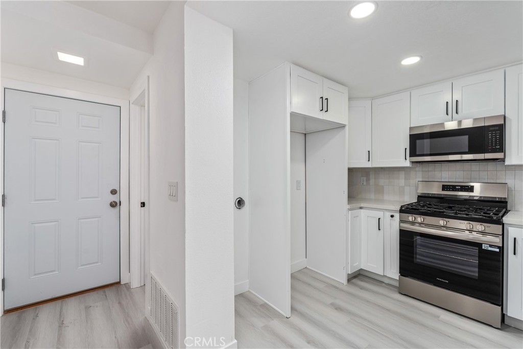 936 Fairway, Unit 8 Grand Terrace, CA 92324 - Photo 12 of 26 a kitchen with stainless steel appliances a stove a microwave and a hard wood floors