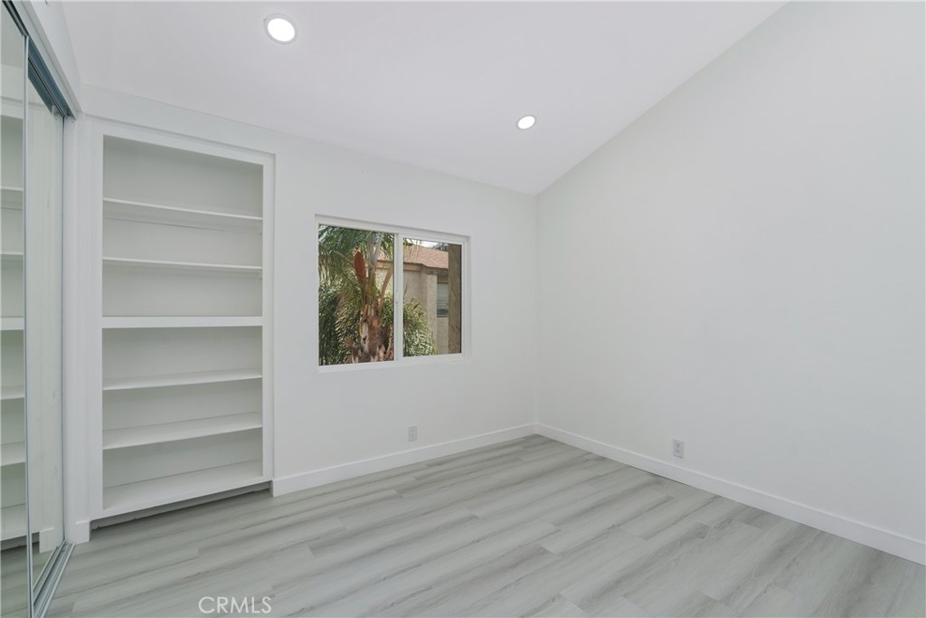 936 Fairway, Unit 8 Grand Terrace, CA 92324 - Photo 16 of 26 a view of an empty room with a window and wooden floor