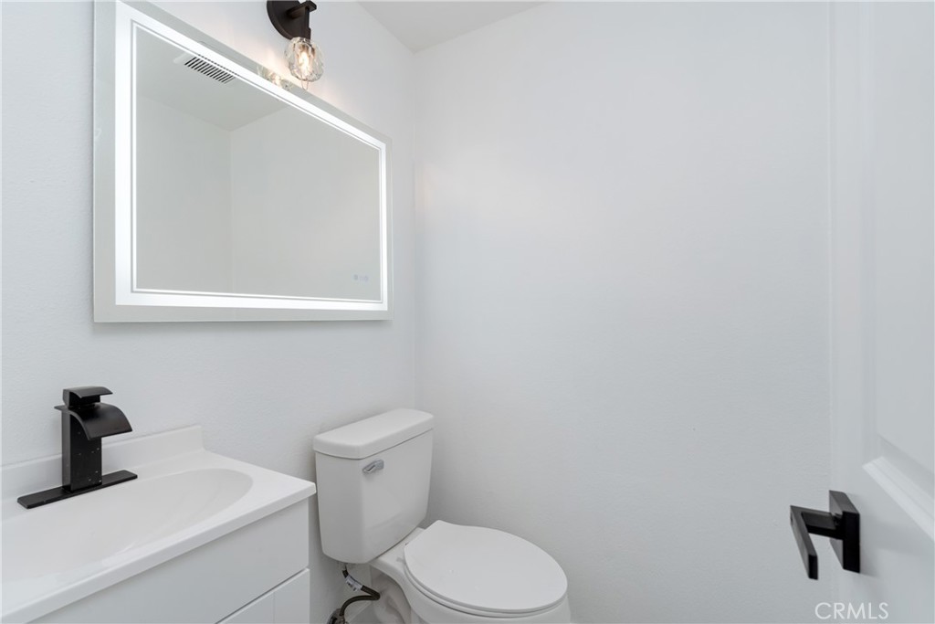936 Fairway, Unit 8 Grand Terrace, CA 92324 - Photo 4 of 26 a bathroom with a toilet sink and mirror