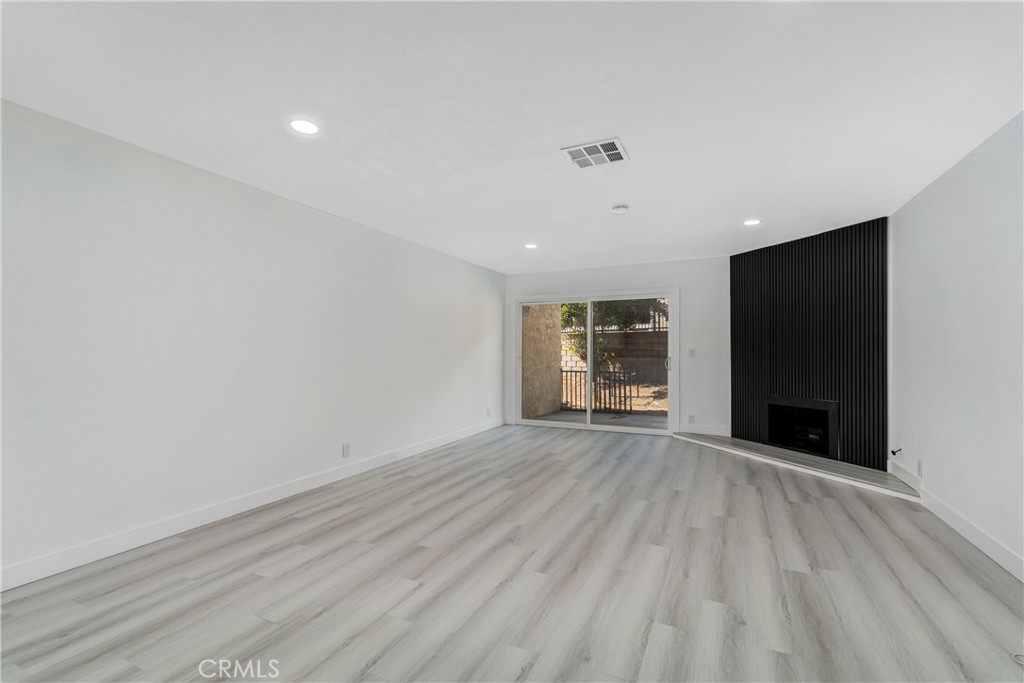 936 Fairway, Unit 8 Grand Terrace, CA 92324 - Photo 5 of 26 a view of an empty room with wooden floor and a window