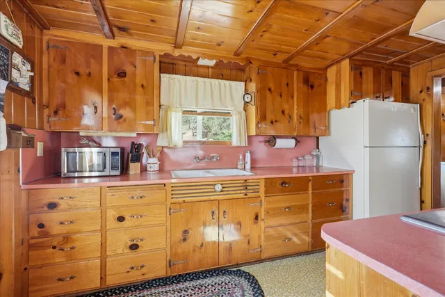 a kitchen with table chairs cabinets and wooden floor