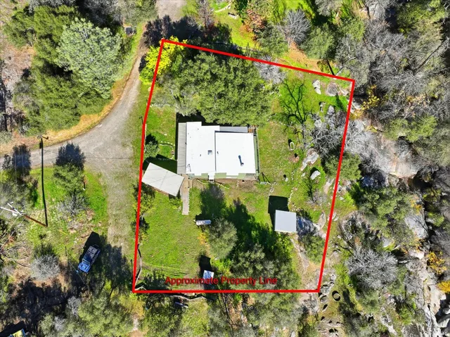 an aerial view of a house with a yard and parking