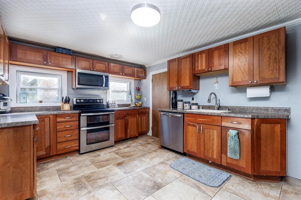 511 North Salisbury Davis, IL 61019 - Photo 7 of 24 a kitchen with stainless steel appliances granite countertop a stove sink microwave and cabinets