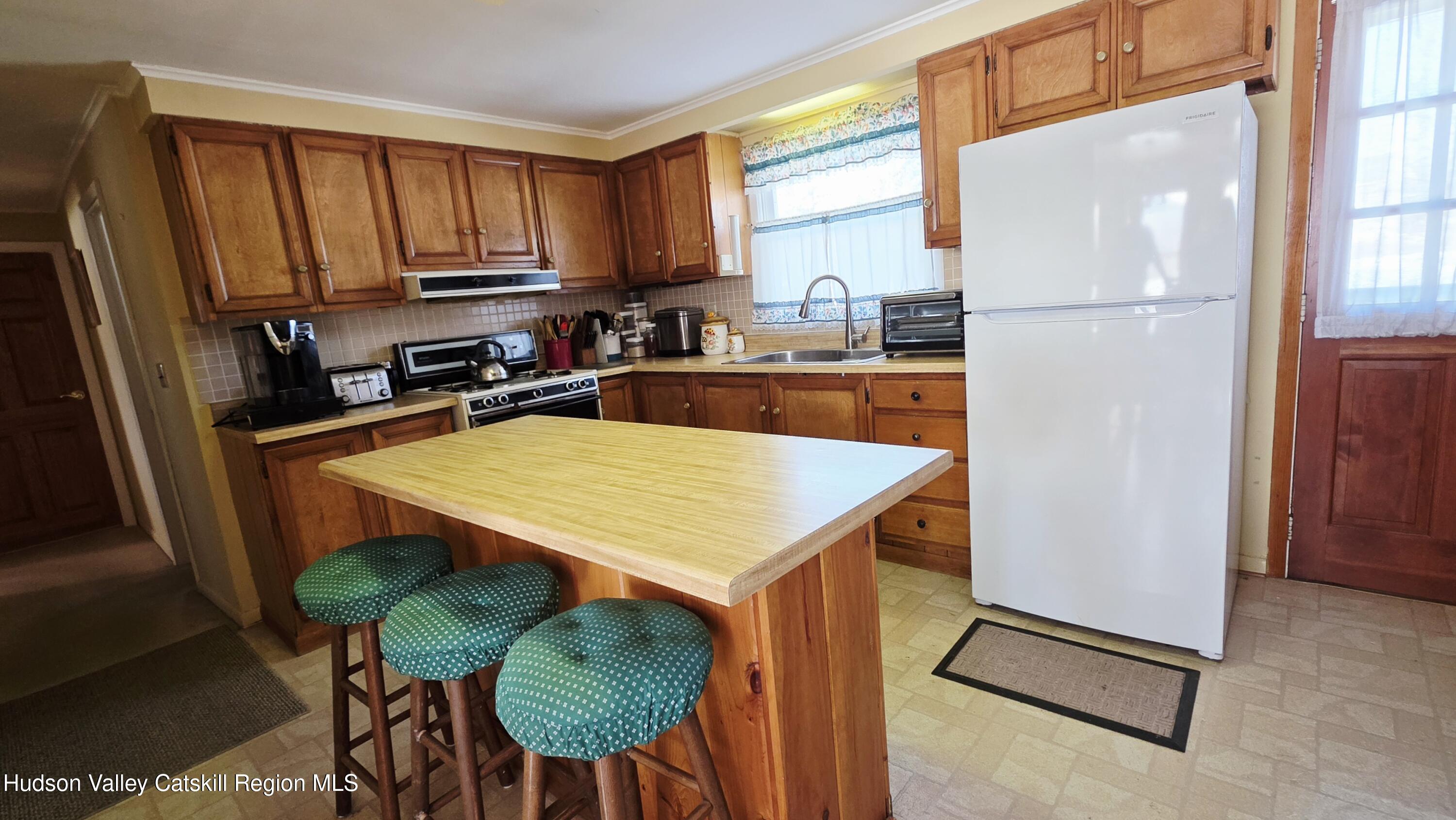334 Stonitch Road East Durham, NY 12423 - Photo 9 of 46 a kitchen with stainless steel appliances granite countertop a refrigerator a stove a sink dishwasher and white cabinets with wooden floor