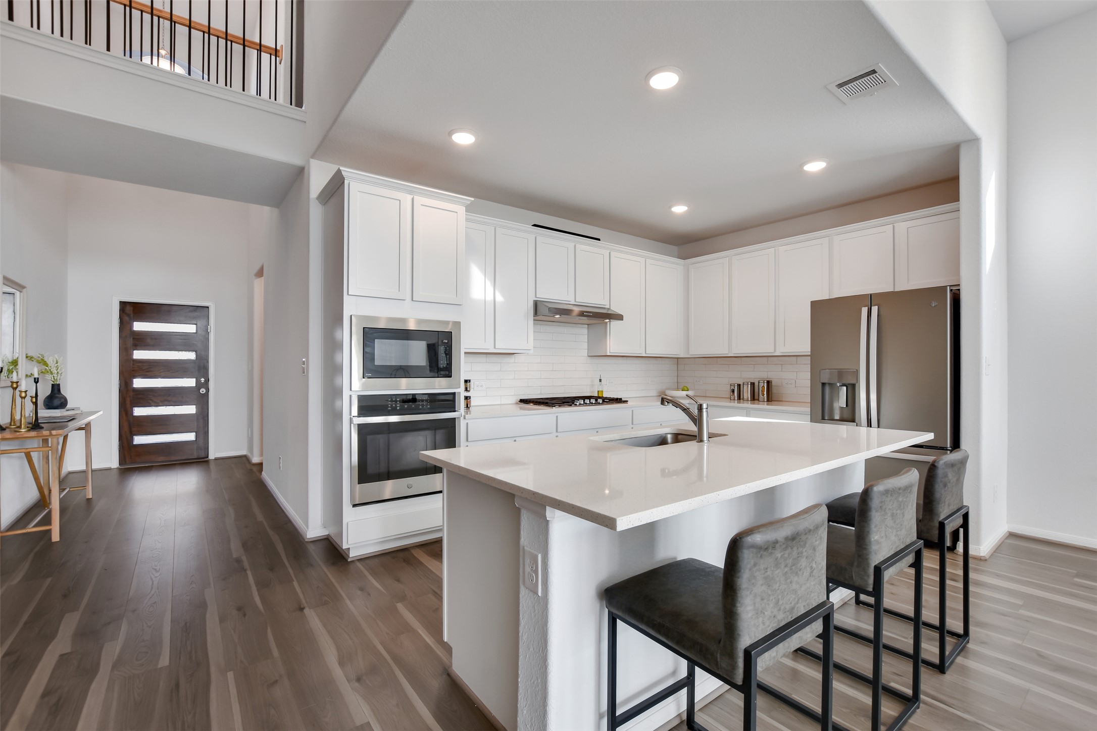 605 Oleander Loop Buda, TX 78610 - Photo 6 of 32 a kitchen with stainless steel appliances granite countertop a table chairs sink refrigerator and cabinets