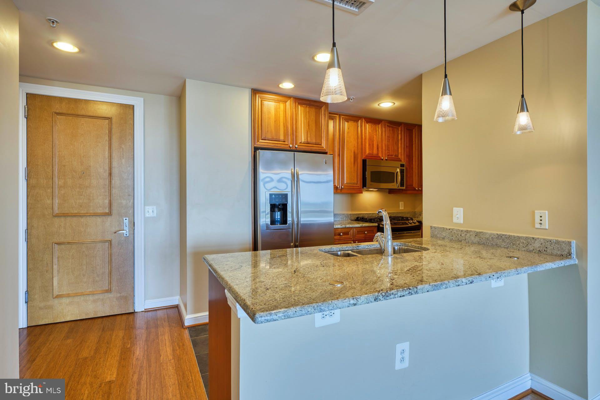 11990 Market Street, Unit 1314 Reston, VA 20190 - Photo 13 of 44 LARGE ISLAND WITH BREAKFAST BAR & PENDENT LIGHTING