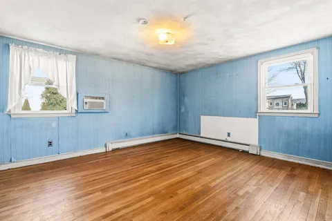 wooden floor in an empty room with a window