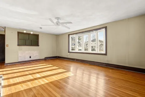 a view of a livingroom with wooden floor and stairs