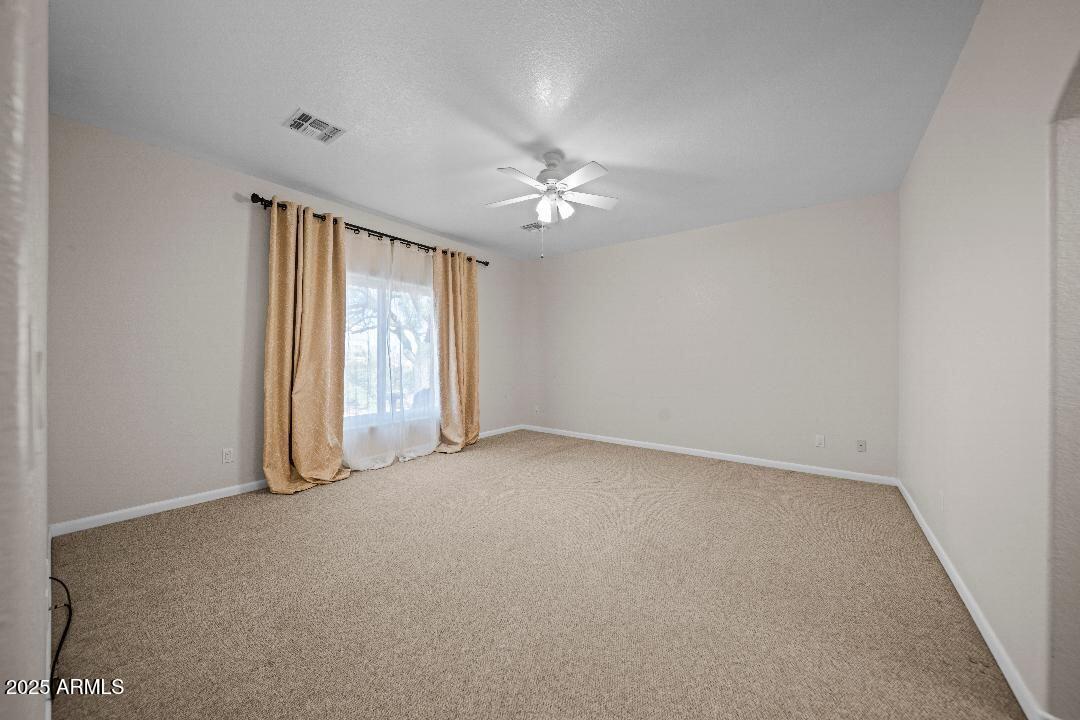 2825 West Pinto Place Wickenburg, AZ 85390 - Photo 11 of 32 an empty room with windows and fan