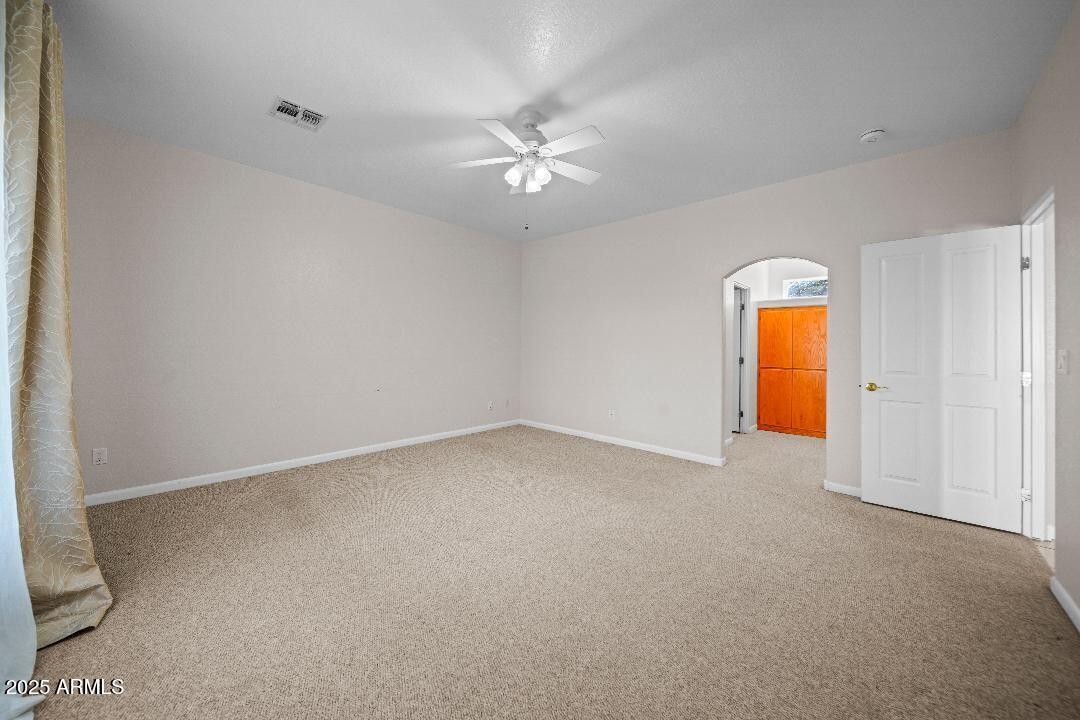 2825 West Pinto Place Wickenburg, AZ 85390 - Photo 12 of 32 an empty room with a ceiling fan and a window