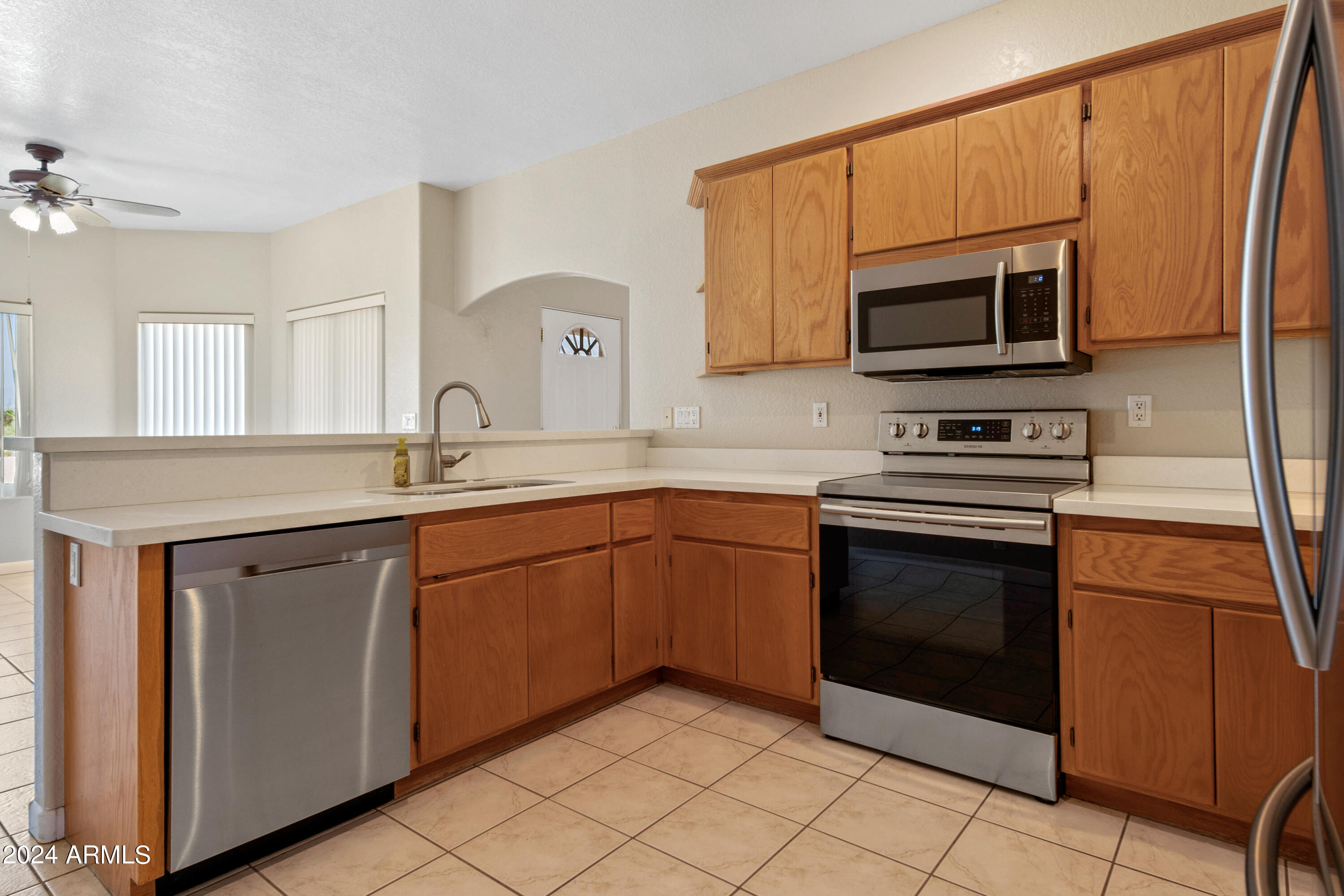 2825 West Pinto Place Wickenburg, AZ 85390 - Photo 9 of 32 a kitchen with stainless steel appliances granite countertop a sink stove and microwave