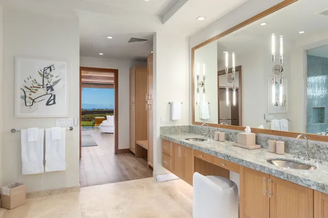 a spacious bathroom with a granite countertop double vanity sink a mirror and a bathtub