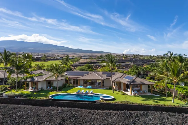 an aerial view of residential houses with yard and mountain view in back