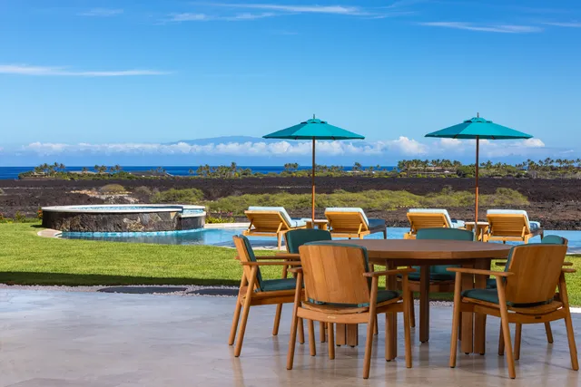a patio with a table and chairs under an umbrella