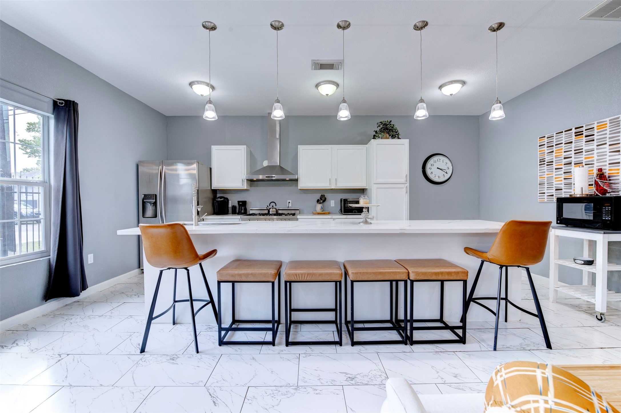 301 Tabor Street Houston, TX 77009 - Photo 14 of 33 a kitchen with stainless steel appliances kitchen island granite countertop a table chair and a refrigerator