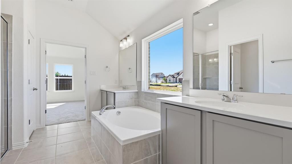 2529 Rivers W Road Anna, TX 75409 - Photo 33 of 40 Contemporary bathroom featuring a built-in soaking tub, dual vanities with white countertops, and a large window