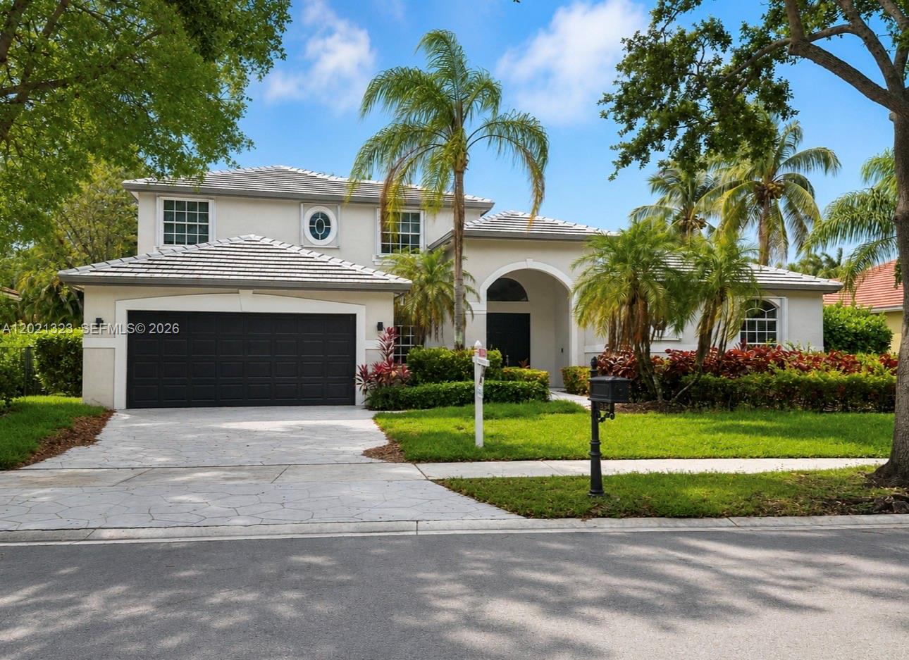 354 Mallard Road, Unit O Weston, FL 33327 - Photo 1 of 29 a front view of a house with a garden and palm trees