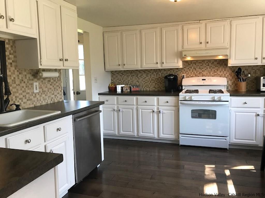 183 Beecher Hill Road Wallkill, NY 12589 - Photo 18 of 33 a kitchen with granite countertop white cabinets and white appliances
