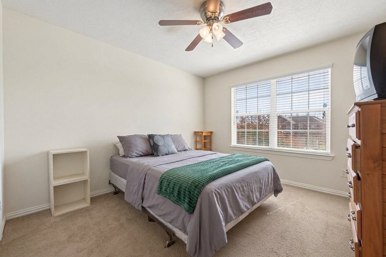 8106 Rudy Brook Way Spring, TX 77379 - Photo 15 of 20 a bedroom with a bed chandelier and a window