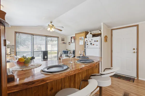 a dining room with furniture a chandelier and wooden floor