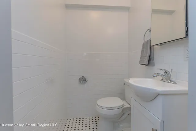 a bathroom with a sink a toilet and a mirror