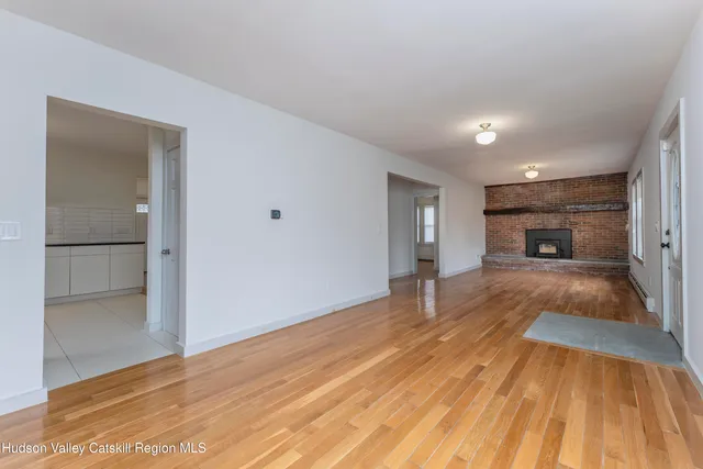 a big room with wooden floor and a fireplace