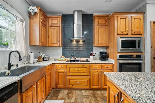 a kitchen with stainless steel appliances granite countertop a sink stove and refrigerator