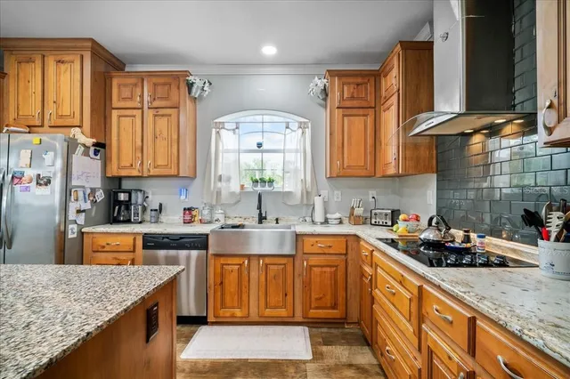 a kitchen with stainless steel appliances granite countertop wooden cabinets a sink and dishwasher