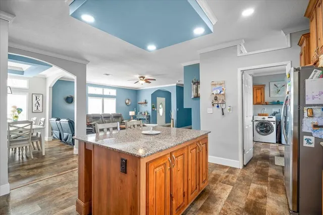 a dining hall with stainless steel appliances granite countertop a sink and cabinets