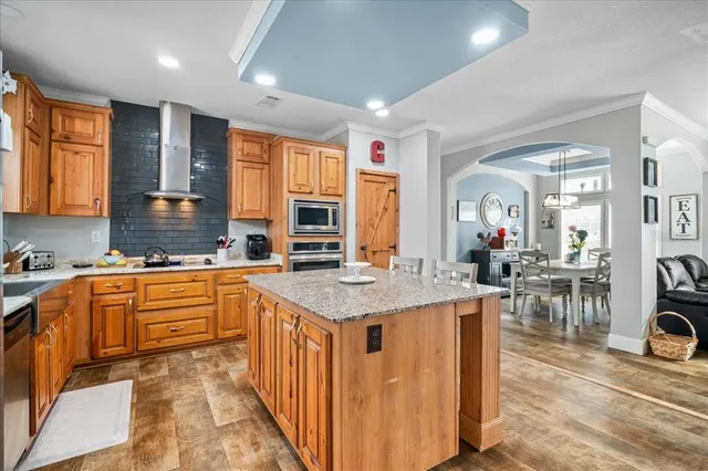 a large kitchen with stainless steel appliances granite countertop a lot of counter space and a sink