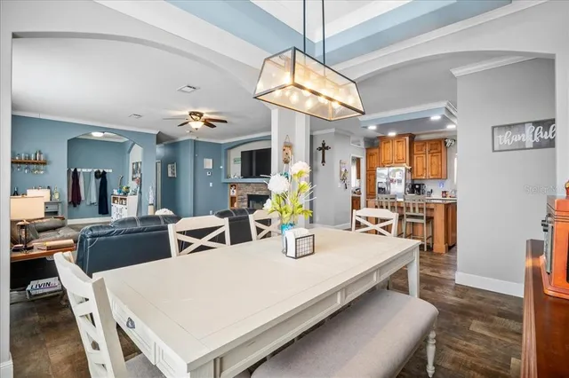 a large white kitchen with a table chairs and a chandelier