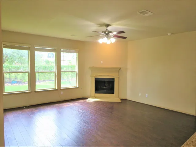 a view of empty room with a fireplace and wooden floor